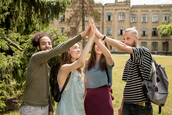 Estudiantes en el campus levantándose manos . — Foto de Stock