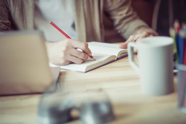 Nahaufnahme eines Mannes, der mit Rotstift Notizen macht. — Stockfoto