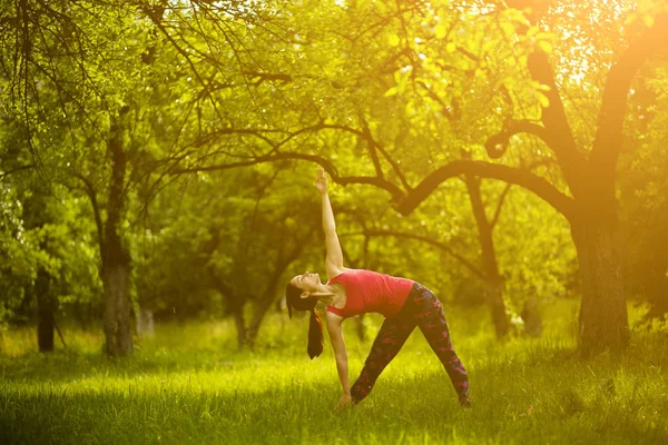 Chica haciendo yoga asana extendido triángulo . — Foto de Stock