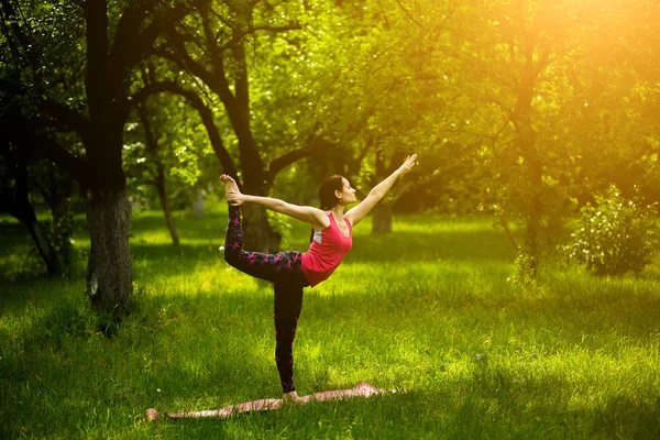 Mujer haciendo entrenamiento de yoga matutino en jardín . — Foto de Stock