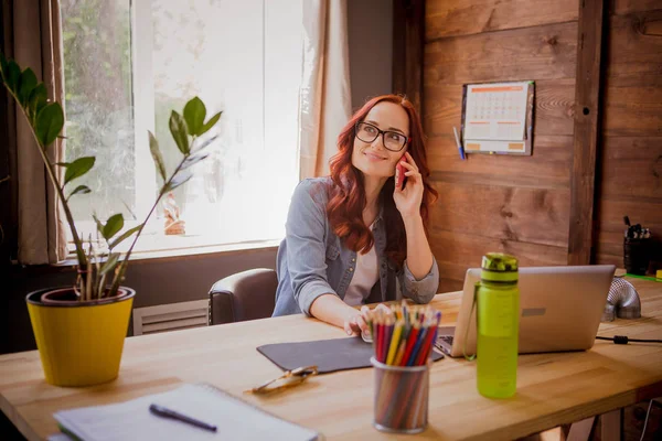 Freelancer γυναίκα εργάζεται, μιλάμε για κινητό τηλέφωνο. — Φωτογραφία Αρχείου