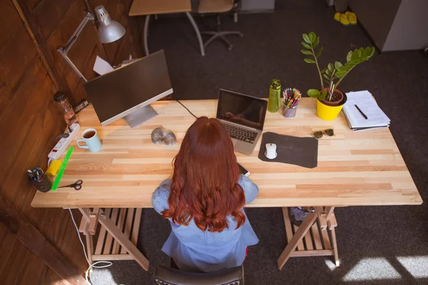 Κάτοψη του τζίντζερ μαλλιά freelancer γυναίκα στο γραφείο. — Φωτογραφία Αρχείου