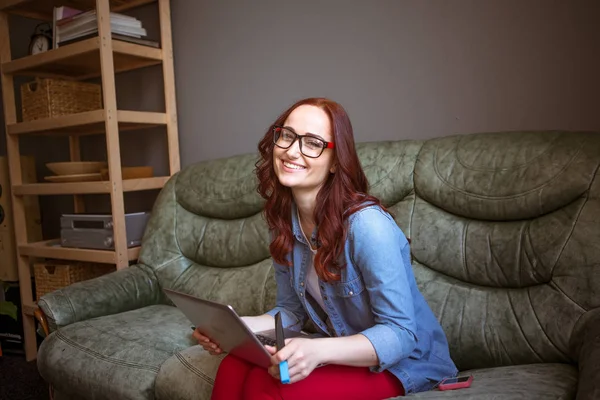 Freiberuflerin sitzt mit Laptop auf Couch. — Stockfoto