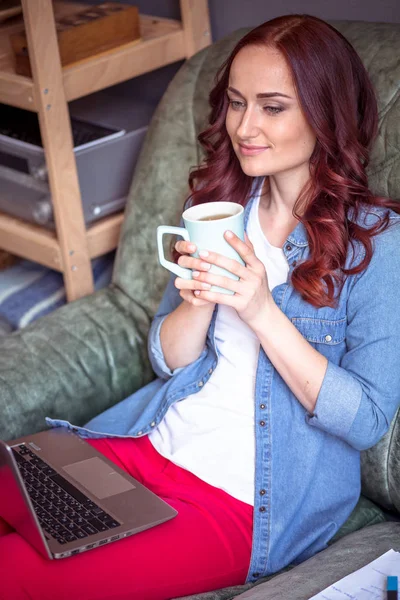 お茶やコーヒーを飲みながらのラップトップに取り組んでフリーランサー女性. — ストック写真