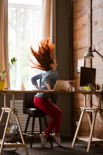 Freelancer ung kvinna att ha kul på din arbetsplats. — Stockfoto
