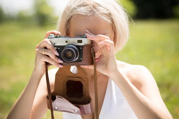 Wanita pirang muda membuat gambar foto dengan kamera vintage . — Stok Foto