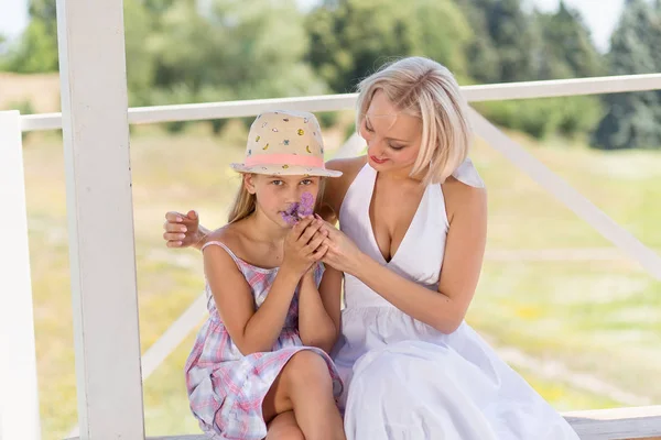 Madre con la sua ragazza liitle, figlia annusare un fiore . — Foto Stock