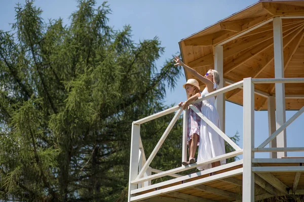 Filha e mãe em pé em alcova no jardim . — Fotografia de Stock