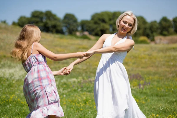 Madre e figlia che ballano in un prato . — Foto Stock