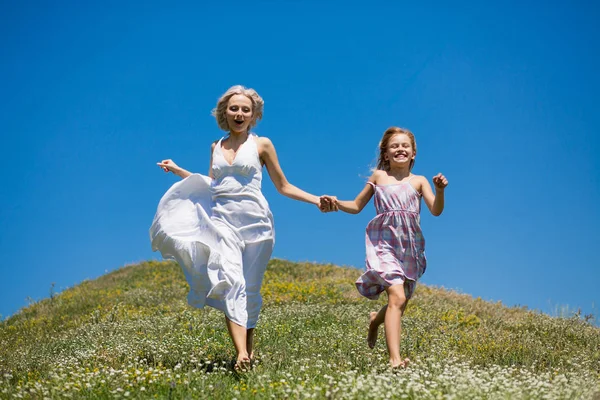 Щаслива концепція дитинства, мати і дочка тримаються за руки, бігають . — стокове фото