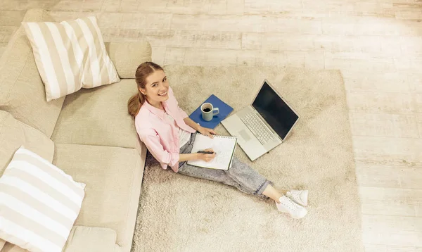 Вид сверху на молодую симпатичную девушку, которая учится дома . — стоковое фото