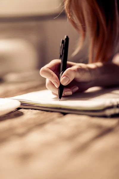 Close up view of womans hand writing in notebook. — Stock Photo, Image