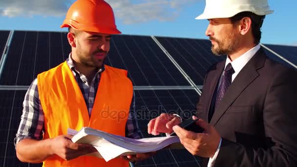 Крупный план бизнес-клиента беседующего с инженером на солнечной электростанции . — стоковое видео