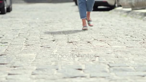 Nahaufnahme von Frauenbeinen, die auf Pflastersteinen gehen. — Stockvideo