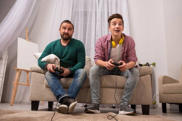 Pai e filho brincando no console em casa . — Fotografia de Stock