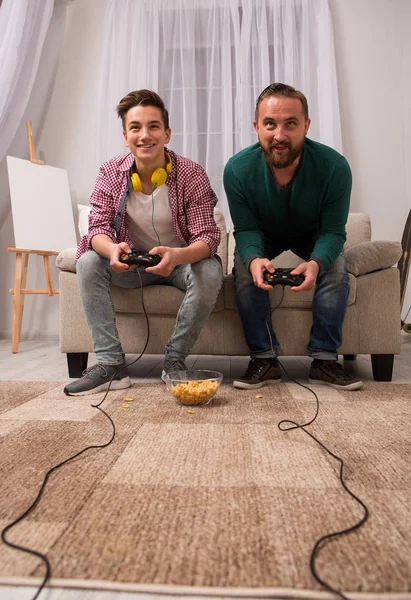 Feliz filho e pai jogando videogame juntos . — Fotografia de Stock