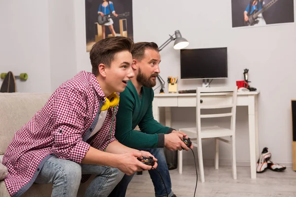 Adolescente pálido consola jogos com o pai . — Fotografia de Stock