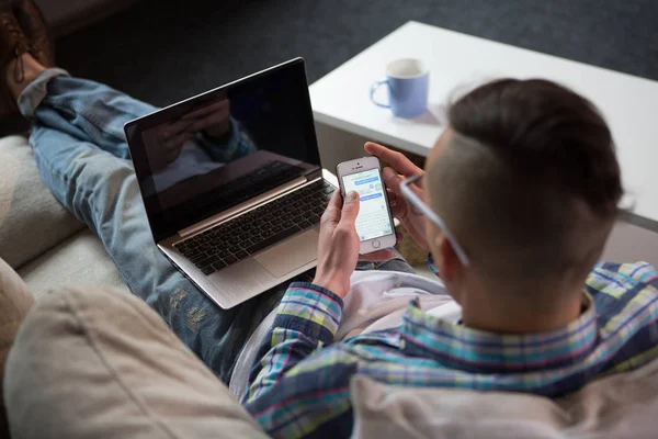 Οπίσθια όψη του freelancer που εργάζονται με το laptop στον καναπέ. — Φωτογραφία Αρχείου