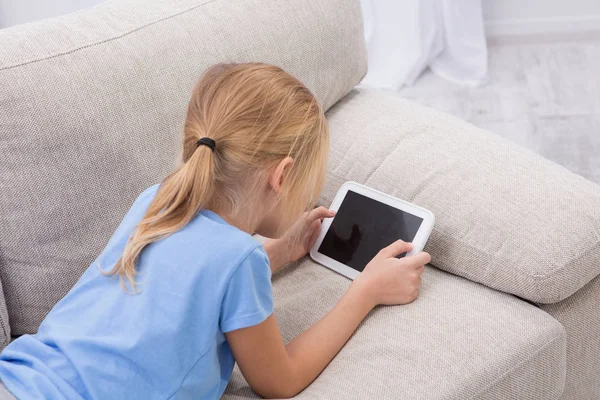 Zieke kind verblijft thuis palying spelen op Tablet PC. — Stockfoto