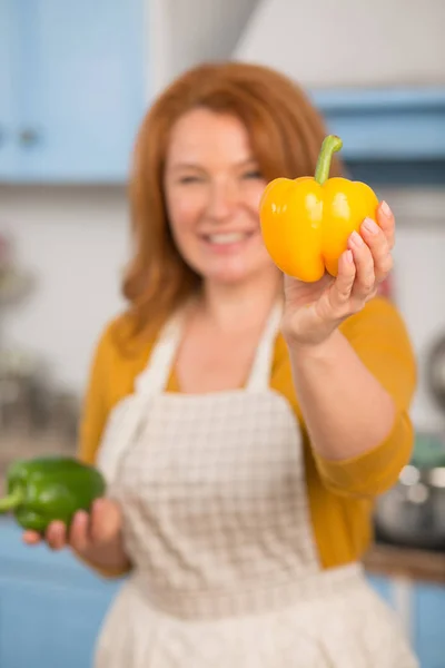 Zblízka pohled žlutá paprika v ruce atraktivní hospodyňka. — Stock fotografie
