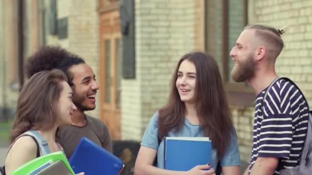 Jeunes étudiants debout sur le campus, communiquer . — Video