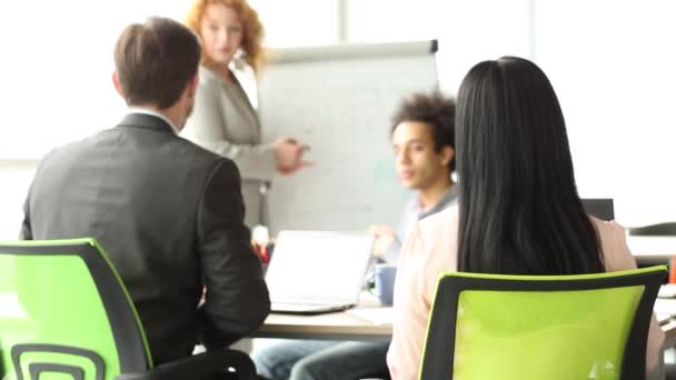 Achteraanzicht van business team tijdens de bijeenkomst, vrouw draaien op stoel met bord in haar handen. — Stockvideo