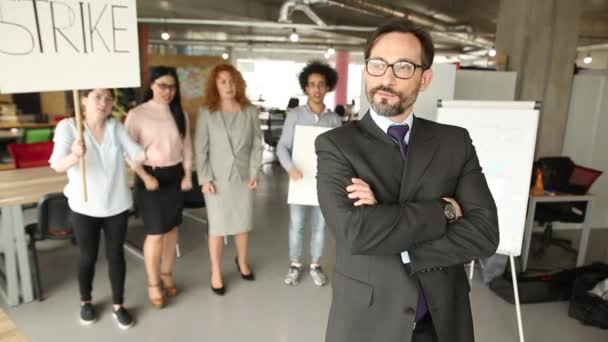 Moderno concepto de oficina, director de pie con su espalda a cowokers llamativos — Vídeos de Stock