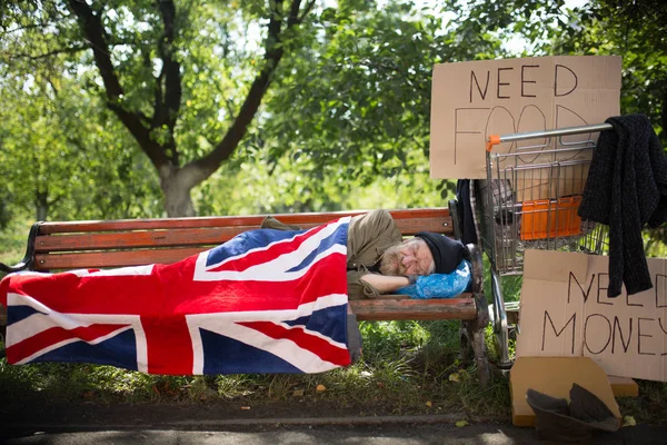 Сплячий бездомний чоловік, що покриває прапором . — стокове фото