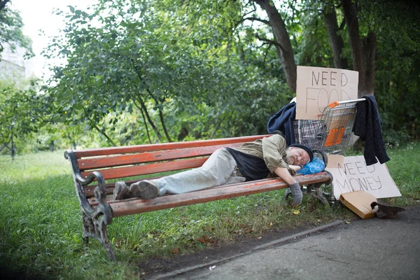 View of homeless old man on the bench in city park. — Stock Photo, Image