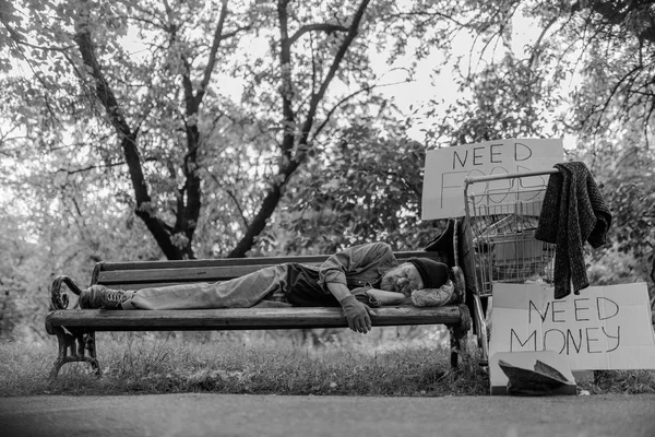 Black and white portrait of homeless man lying on bench. — Stock Photo, Image