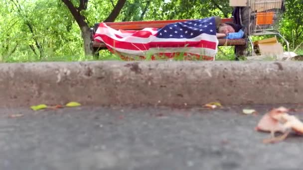 一个无家可归的人，睡在街上的长凳上的视图. — 图库视频影像