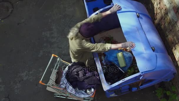 Vista superior do homem sem-teto se aproximando lata de lixo com carrinho de compras . — Vídeo de Stock