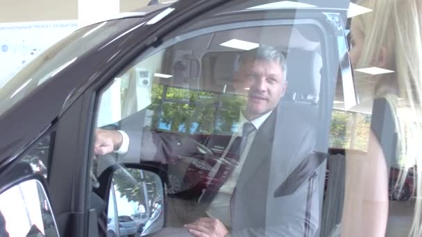 Blick eines Händlers, der dem Kunden ein neues Auto zeigt, — Stockvideo
