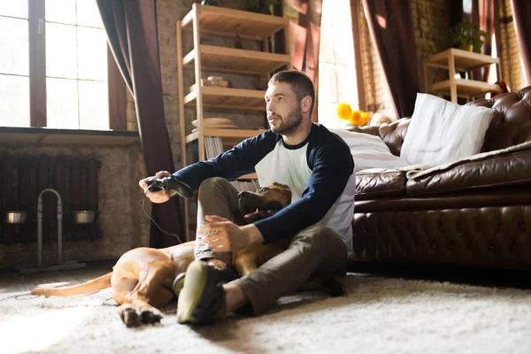 Man en hond op de vloer thuis. — Stockfoto