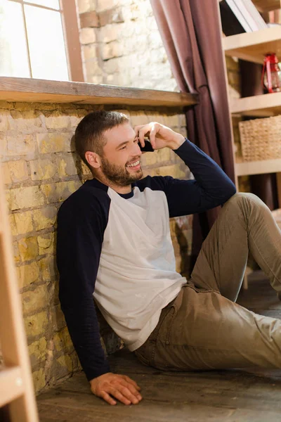 잘생긴 남자가 전화 통화 창으로 바닥에 앉아. — 스톡 사진