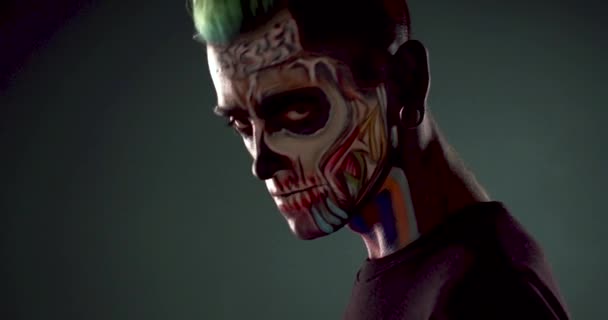 Mann mit grünen Haaren und farbigem Totenkopf-Make-up. — Stockvideo