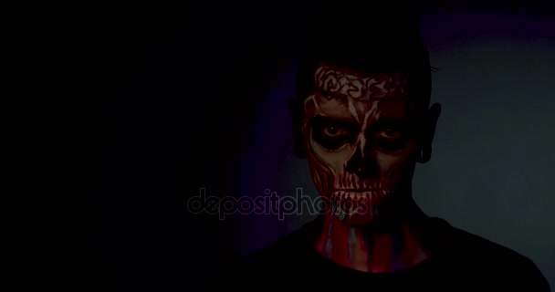 Man with colored skull makeup showing evil smile. — Stock Video