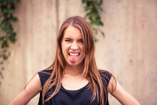 Krásná mladá žena zobrazeno jazyk. — Stock fotografie