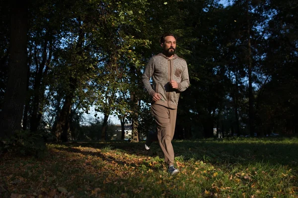 Gesunder Lebensstil, Mann läuft auf Gras im Wald. — Stockfoto