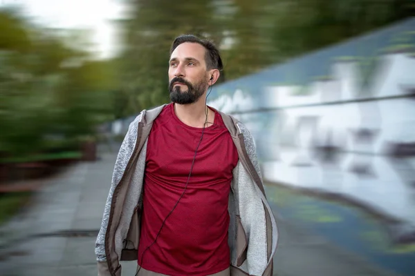 Bonito homem de sportwear correndo no parque urbano . — Fotografia de Stock