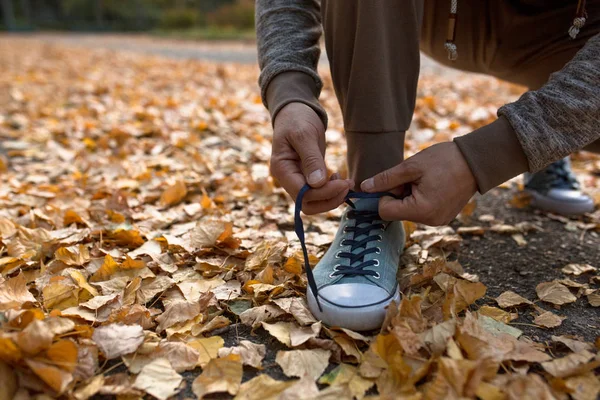 Чоловік зав'язує шнурки взуття перед тим, як бігти на відкритому повітрі . — стокове фото