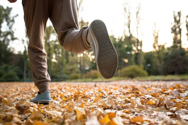 Close-up van man loopt op gedroogde Herfstbladeren. — Stockfoto