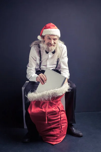 Babbo Natale capo tirando laptop dalla borsa regalo . — Foto Stock