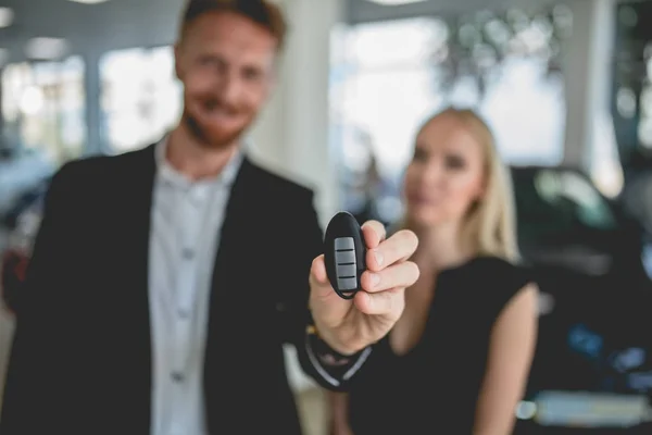 Pasangan muda menunjukkan kunci dari mobil elektro baru . — Stok Foto