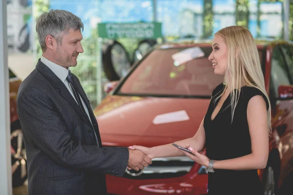 Happy young female shaking had with auto dealer. — Stock Photo, Image