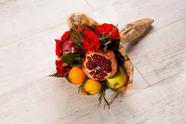 Ładnie zapakowane kompozycja czerwonych róż i owoców. — Zdjęcie stockowe