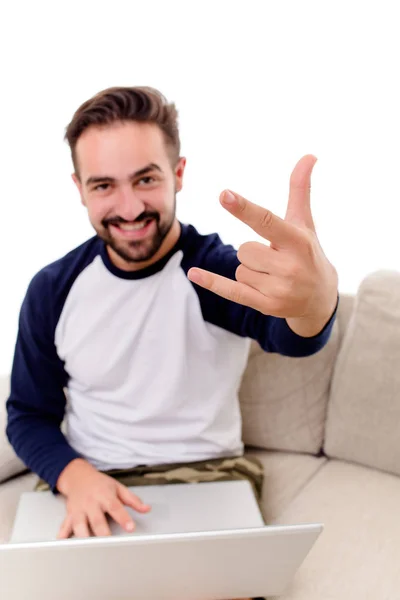 Przystojny młody mężczyzna siedzi na kanapie, Wyświetlono gesty z palm. — Zdjęcie stockowe