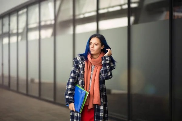 Ung student promenad genom staden med blå mapp. — Stockfoto