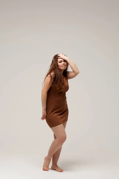 Модель plus size в коричневом коротком платье — стоковое фото