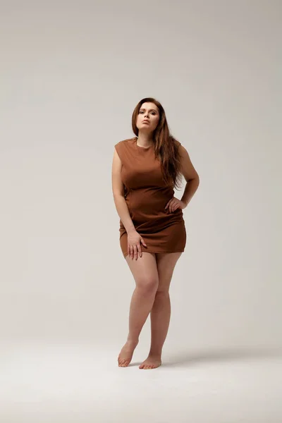 Модель plus size в коричневом коротком платье — стоковое фото